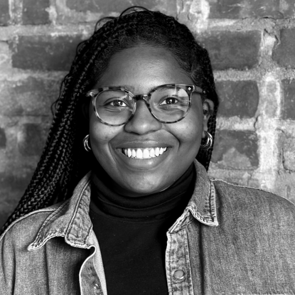woman in glasses smiles at camera