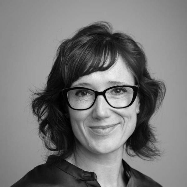 Professional Woman with dark glasses smiles at camera