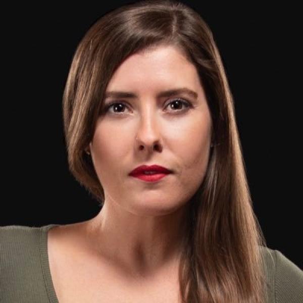 woman with dark hair looks at camera