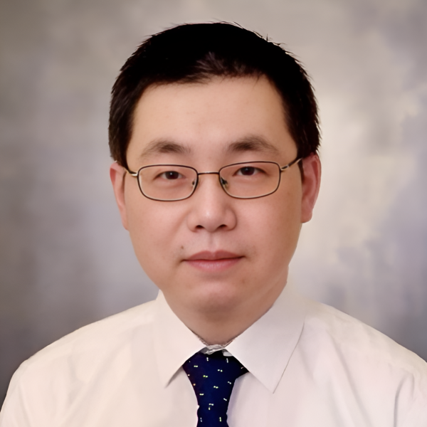 Professor Sheng Lu sits, wearing a white shirt and a dark tie. He wears glasses and has short dark hair.