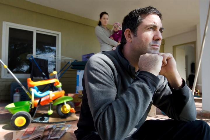 Frustrated man at home with family in the background