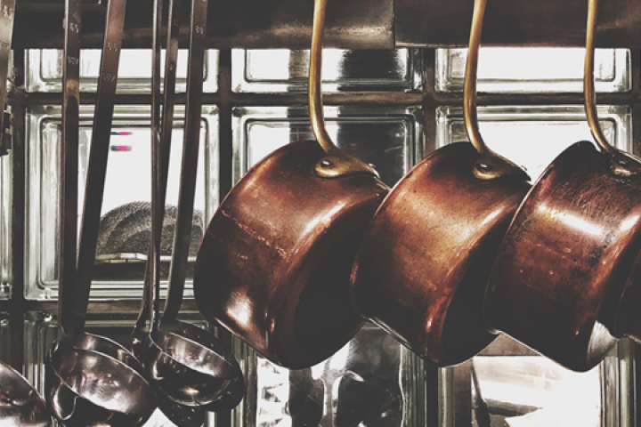 Copper pots hanging in restaurant kitchen