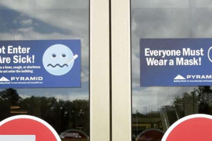 Safety signs are seen on the doors at Crossgates Mall.  Lori Van Buren / Times Union