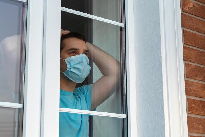 man in mask in quarantine at home