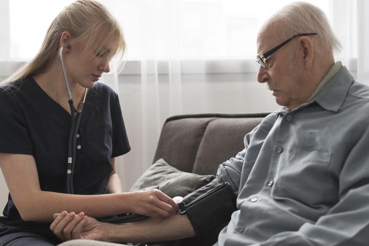 A home healthcare worker checks a patient's blood pressure