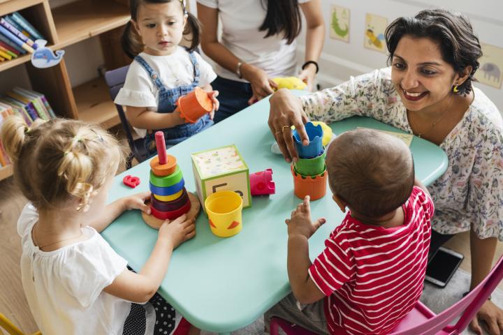 A teacher interacts with students at a daycare.