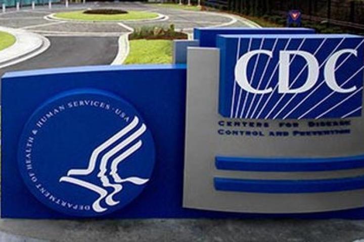 Center for Disease Control logo on a blue background in a field of grass