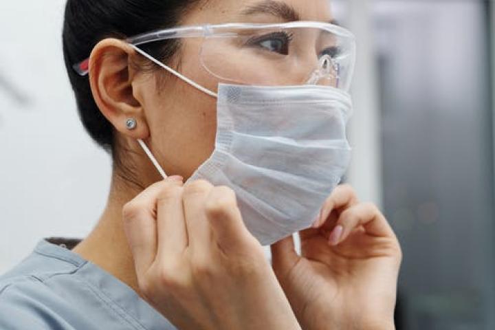 Image of a nurse putting on a mask.