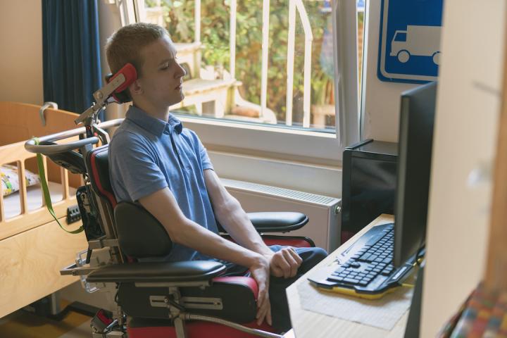 young person with a disability uses computer technology to create an absentee ballot at home