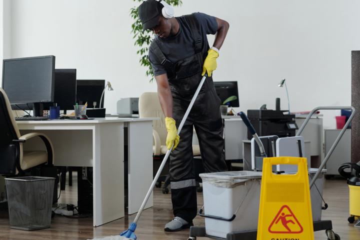 A janitor working after hours in an office. 
