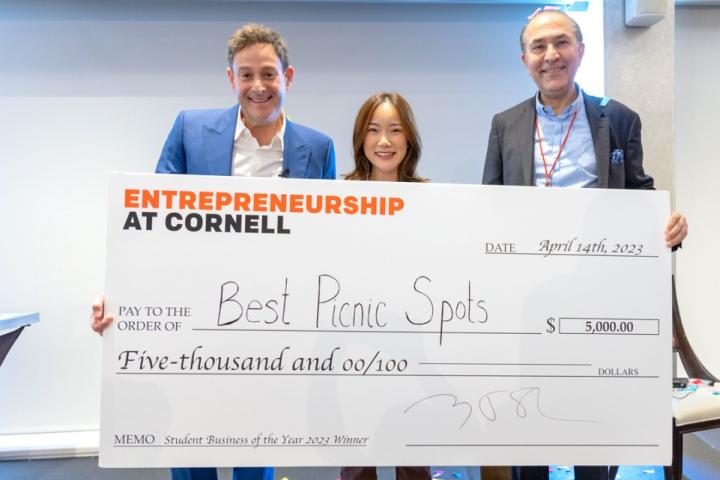 Cornell Entrepreneur of the Year Barry Beck ’90, left, and Sam Sotoodeh MBA ’87, right, present the Student Business of the Year award to Karlie Chen ’23, center, founder of Best Picnic Spots.