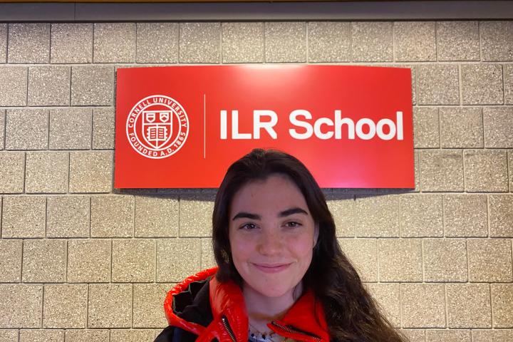 Callie Burns smiling in front of ILR sign