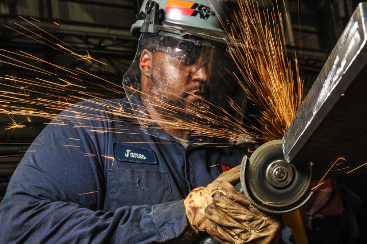 A worker sawing metal