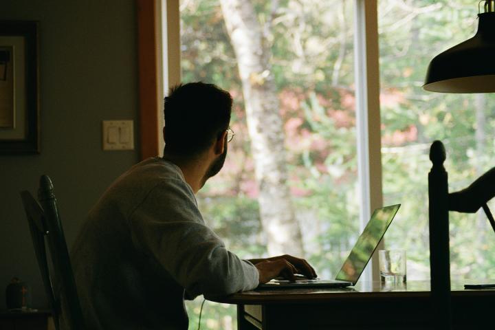 Photo of man at a desk looking out the window