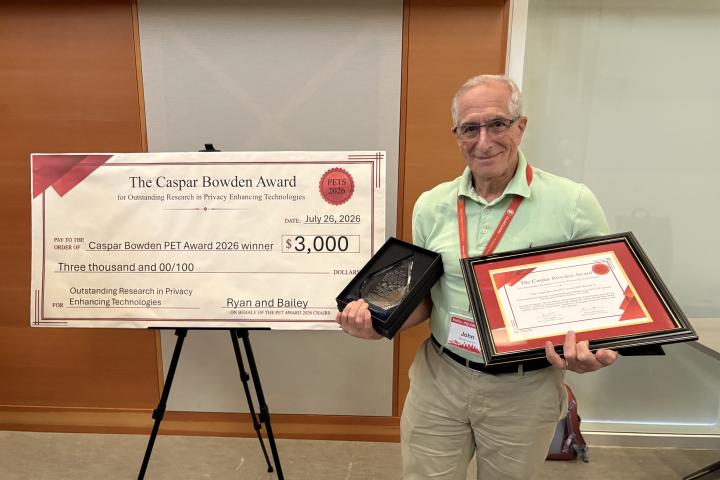 John Abowd poses with the 2026 Caspar Bowden PET Award for Outstanding Research in Privacy Enhancing Technologies