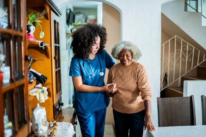 A homecare worker helping elderly woman walk