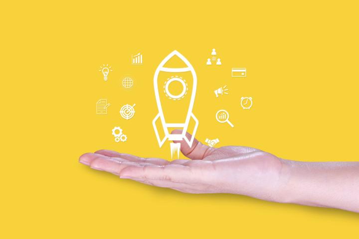 A hand supports a rocket icon surrounded by symbols representing growth, strategy, collaboration, and business development.