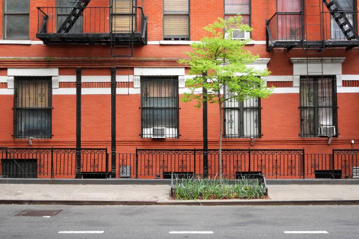  Brick facade of an old building with windows, outdoors staircases and railing in Manhattan