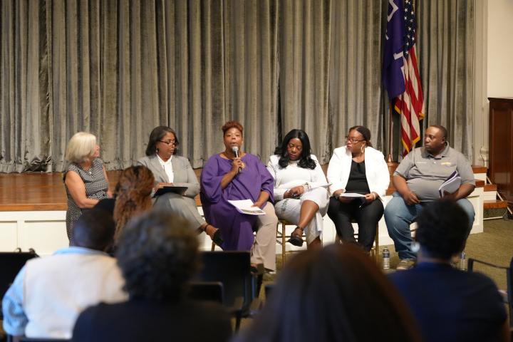 5 panelists and moderator sit