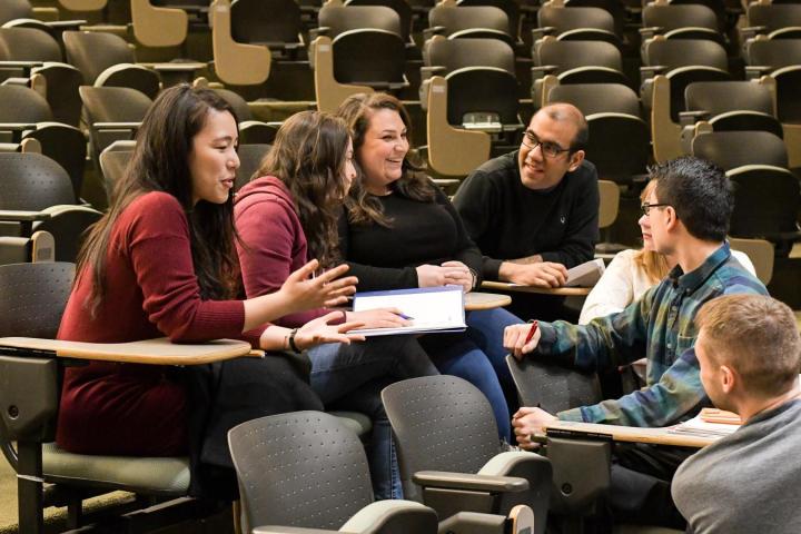 students talking in a circle at desks