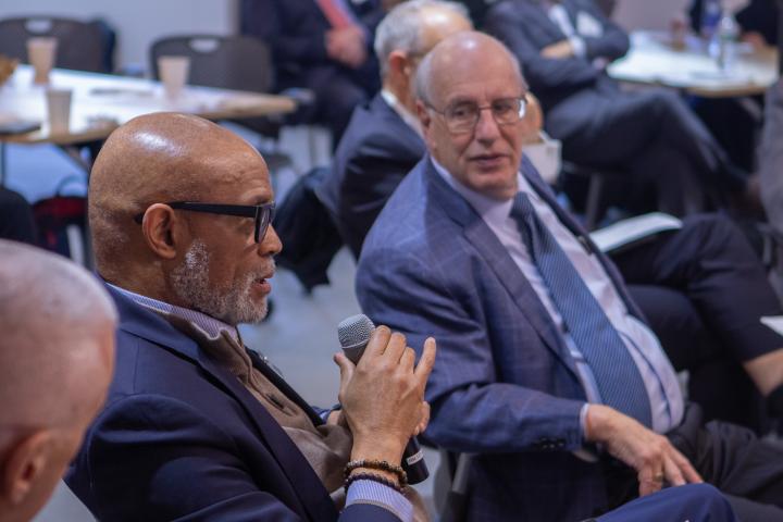 Picture of harry katz speaking to man sitting next to him