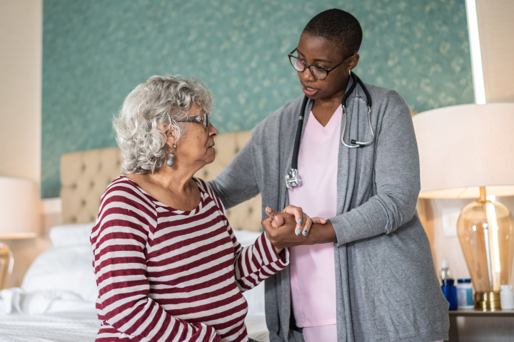 A home healthcare worker helps and elderly woman 