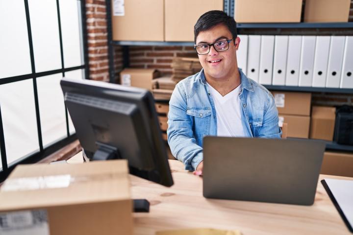A mailroom employee works with a laptop computer