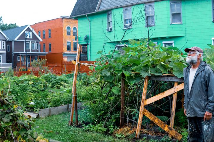 West Side resident Bob Jahnke, a longtime member of the PUSH Community Development Committee, walks through one of the community gardens in his neighborhood.