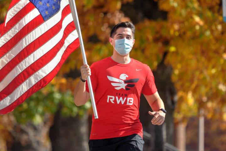 Michael Sanchez, a veteran of the United States Marines and ILR student, carries an American flag while on a weekly run with Team Red, White and Blue, a nonprofit veterans organization.