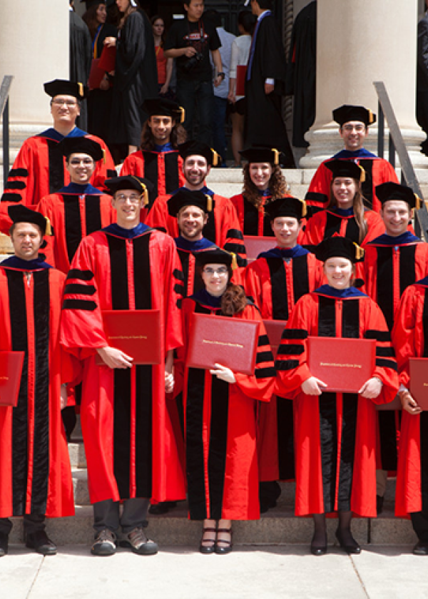 PhD students wearing red robes at Commencement