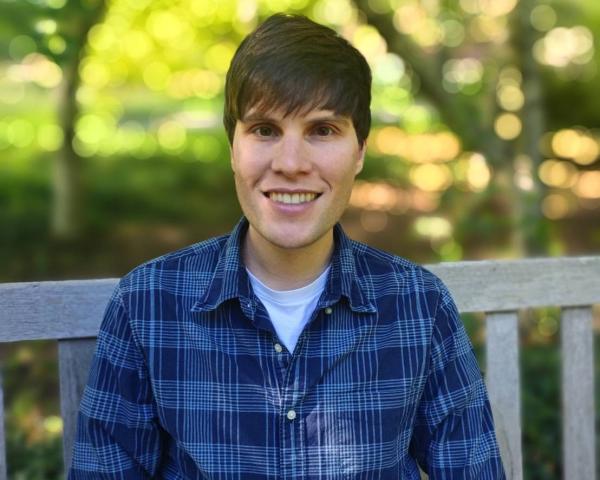 portrait of Paul Merritt outside on a bench