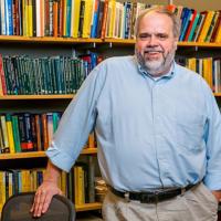 Marty Wells standing in front of a bookcase.