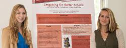 Two undergraduate researchers stand on either side of their poster for Bargaining for Better Schools 