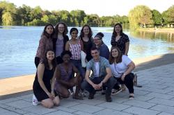 10 students pose in front of small lake