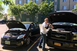 A student attempts to start a Prius iwth jumper cables and another car's battery